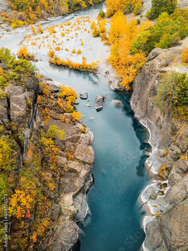 Fototapeta Naklejka Na Ścianę i Meble -  Aerial view of picturesque and tranquil place with a calm river in a rocky gorge during a colorful autumn. Majestic Indian summer in a nature park