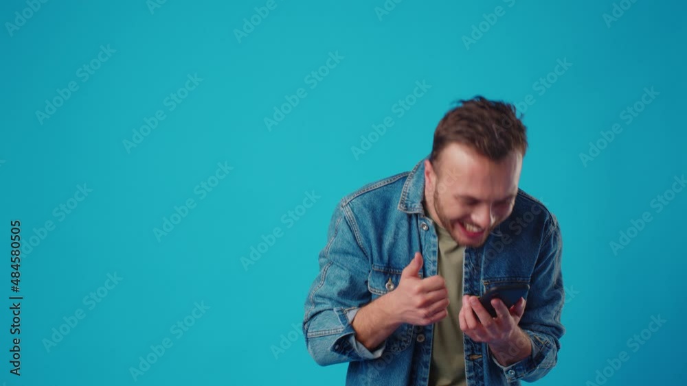 Happy man typing sms on blue background Happy man typing sms on blue background