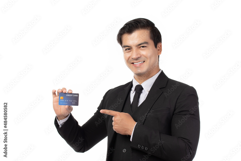 Handsome business man in black suit holding and finger pointing to credit card isolated on white background. Business, technology, ecommerce and online payment concept. Handsome business man in black suit holding and finger pointing to credit card isolated on white background. Business, technology, ecommerce and online payment concept.