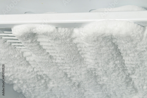 Ice in the freezer. Cleaning the refrigerator from ice and snow