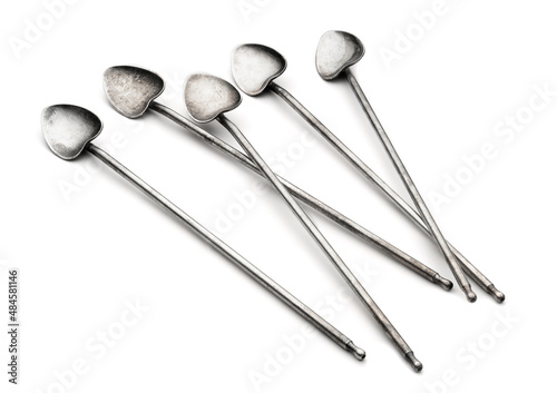 Old vintage silver cocktail spoons isolated on a white background.
