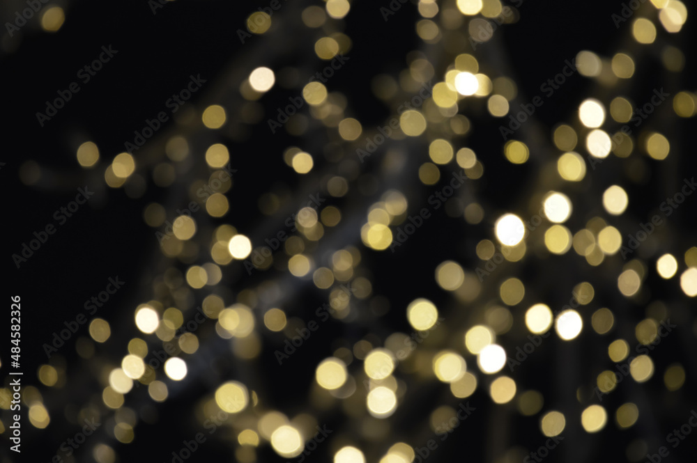 the bokeh lights are yellow. Festive shiny background for celebrating Merry Christmas and Happy New Year. decoration of the city for winter holidays.