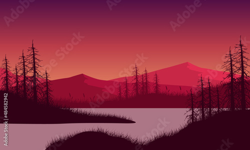 Great mountain view with dry tree silhouette from the riverside at sunrise