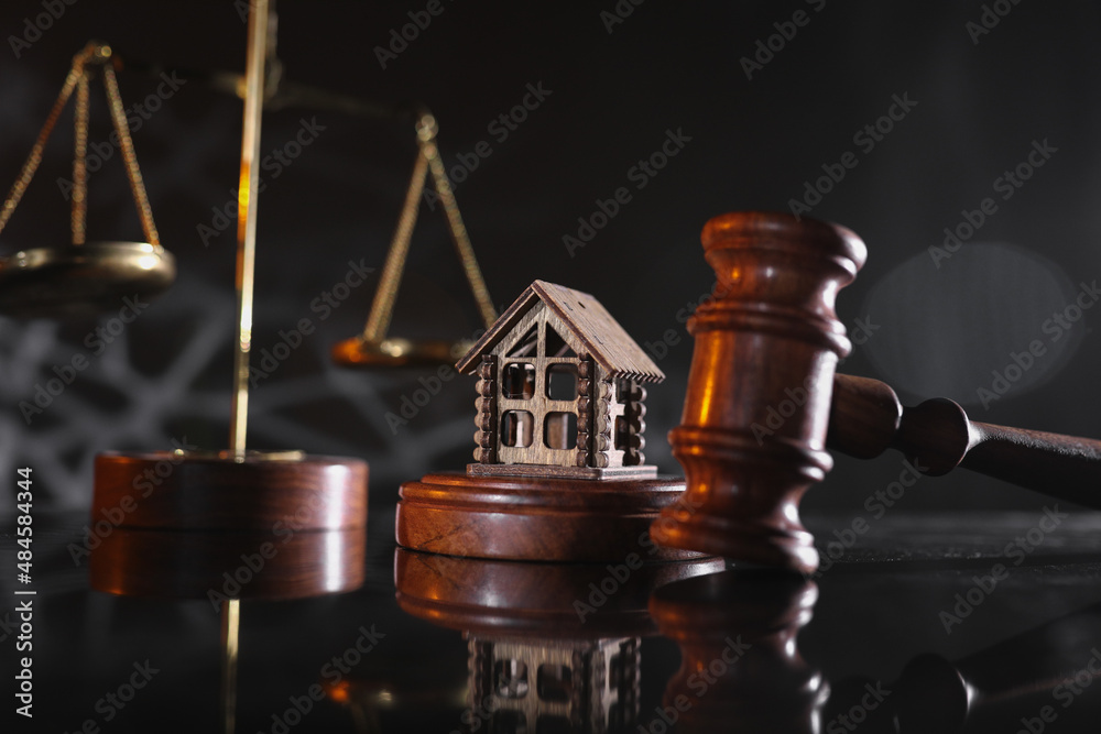 Concept of suing for property. Wooden gavel with house close-up
