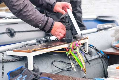 An angler installs an echo sounder on board the boat.