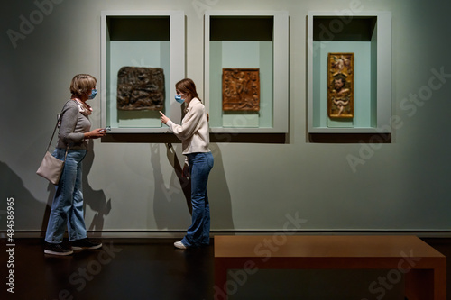 Visitors look at the artworks of the exhibition