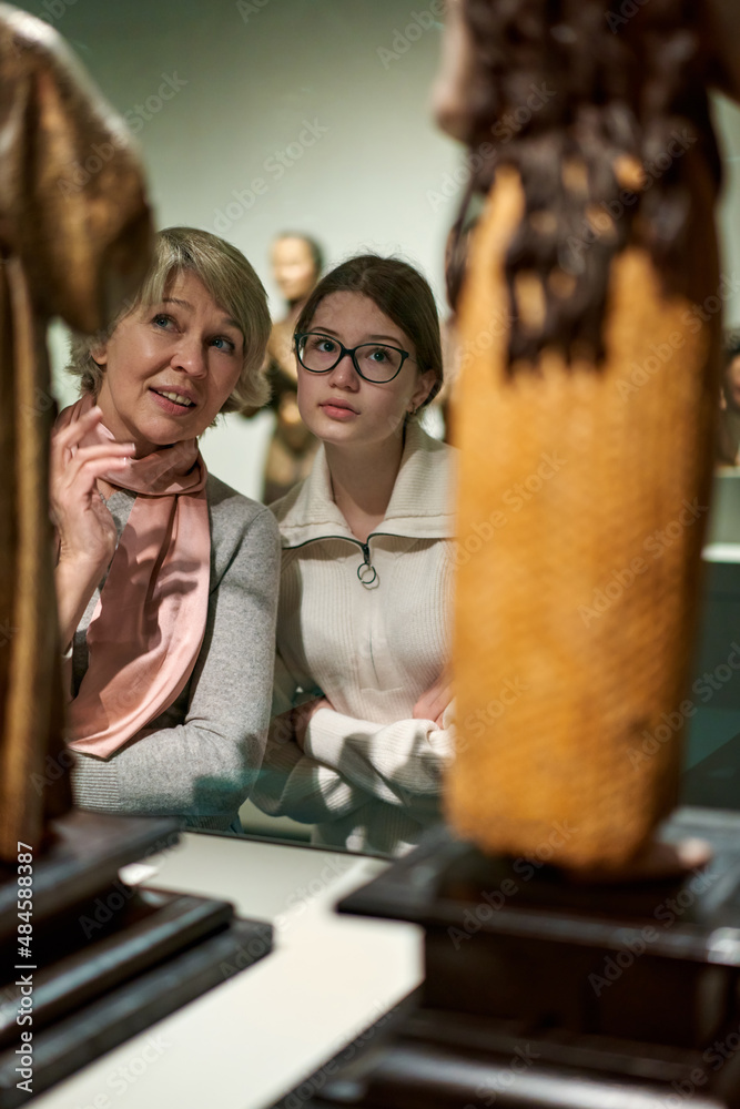 woman visitor with daughter looking to art in museum