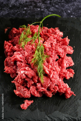 fresh raw ground beef meat heap on black background. Top view.
