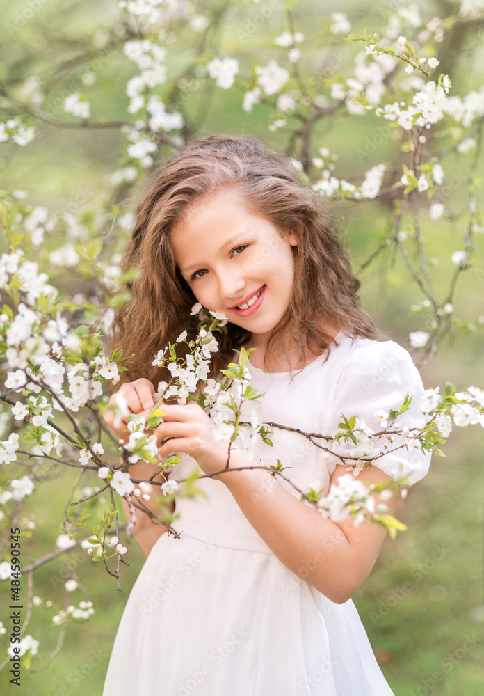 A girl in a white dress in a blooming garden. Spring Garden A girl in a white dress in a blooming garden. Spring Garden
