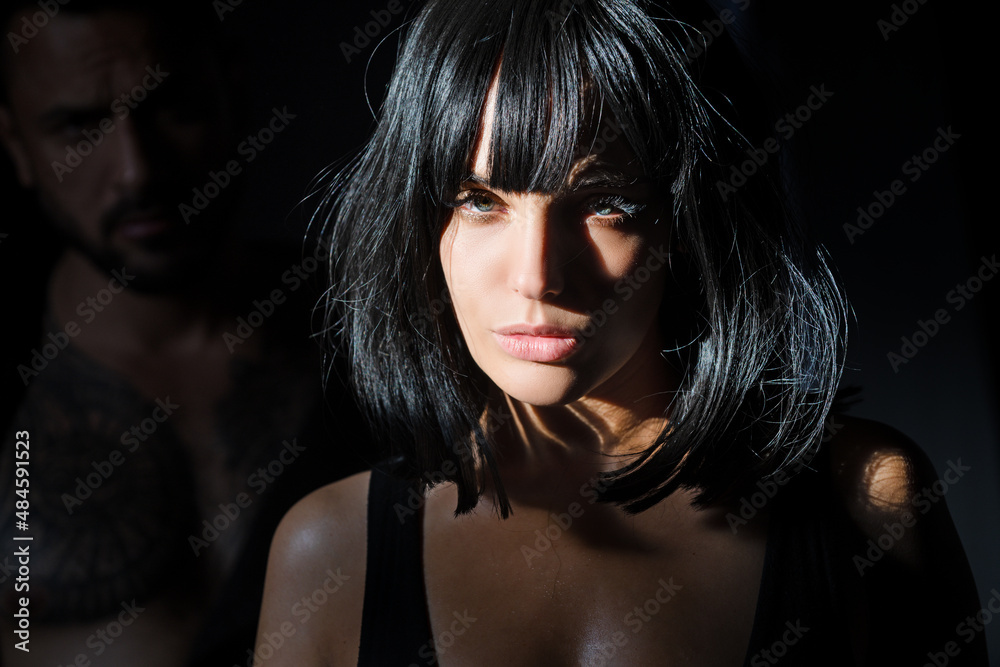 Brunette seductive girl with sexy man on black background. Woman in shadow. Female model with shadows on face looking seductive and sensual on dramatic black studio with light. Brunette seductive girl with sexy man on black background. Woman in shadow. Female model with shadows on face looking seductive and sensual on dramatic black studio with light.