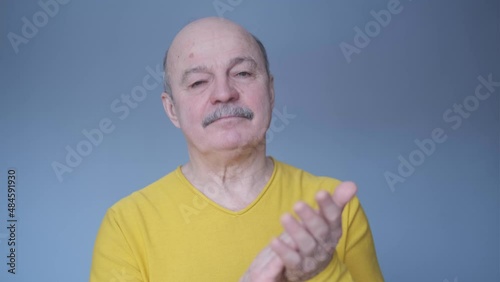 Senior man clapping and applauding happy and joyful, smiling proud