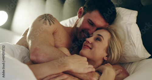 If perfect was a moment this would be it. Young couple being intimate in bed at home. Passionate man and woman sharing romantic moment in the bedroom. Love, romance and sex