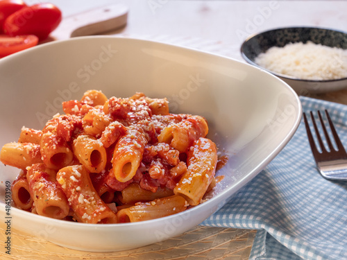 dish of Amatriciana. Italian pasta recipe with tomato sauce, bacon and parmesan on top.Tomato sauce macaroni. Italian food.