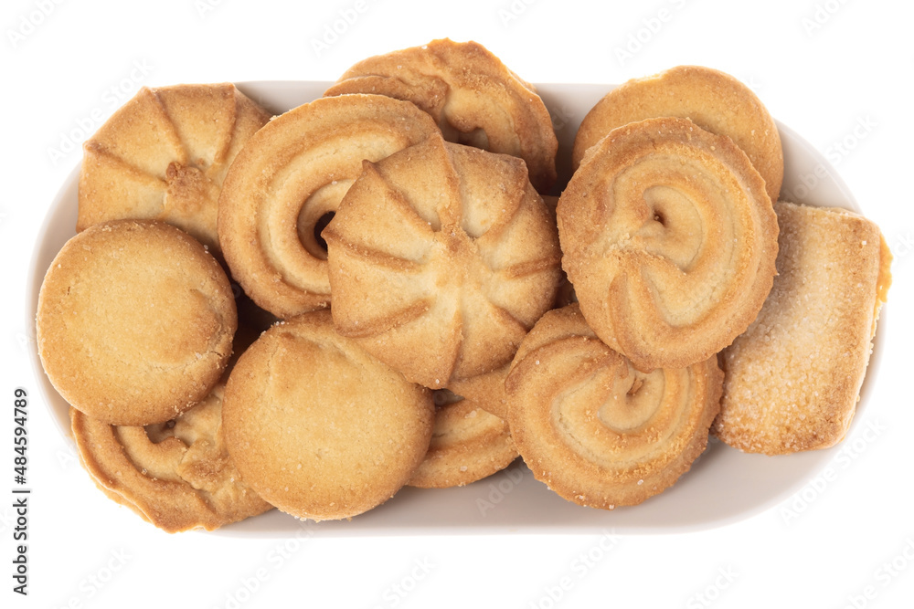 Assorted various forms of danish crumbly cookies on a white plate isolated. Shooting from above, harsh light from the left. Assorted various forms of danish crumbly cookies on a white plate isolated. Shooting from above, harsh light from the left.