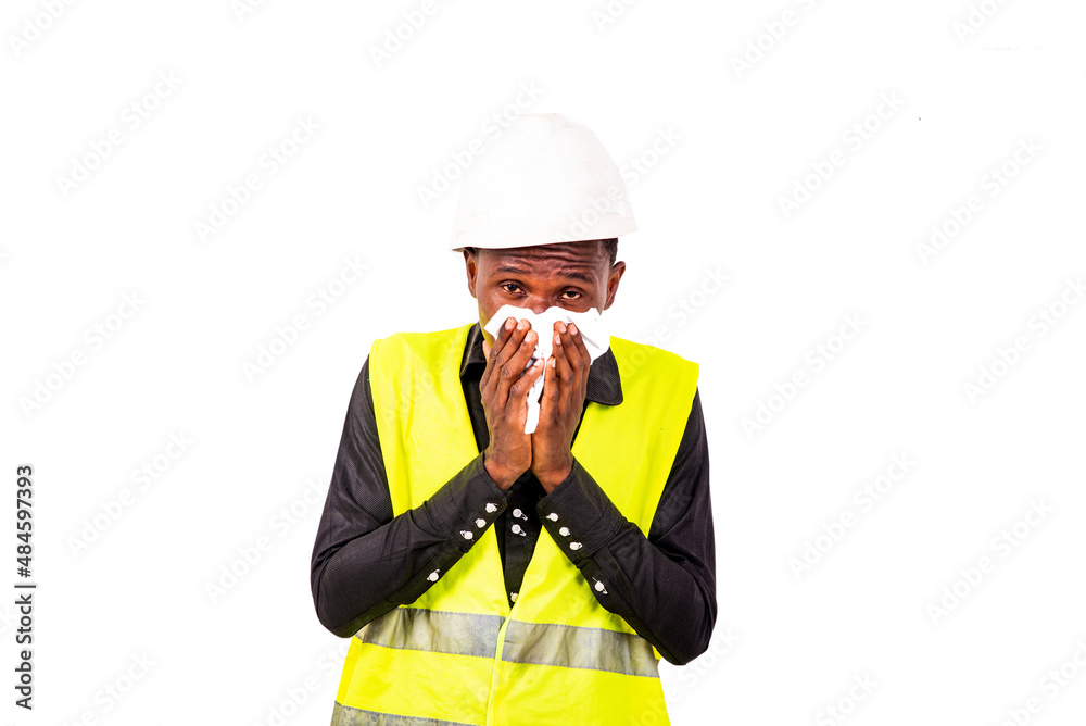 young man engineer sneezing into a handkerchief. young man engineer sneezing into a handkerchief.