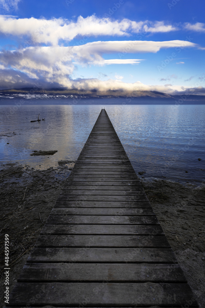 Ponton sur le lac de Neuchâtel au centre avec le jura en arrière plan.