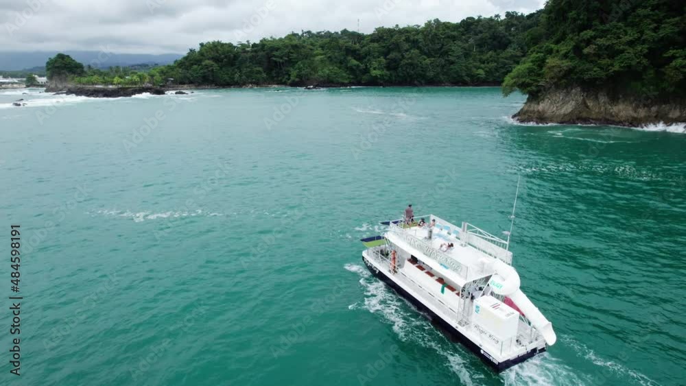 Aerial dolly in of boat sailing in turquoise sea near hill shore covered in green rain forest, Nahomi Park, Costa Rica Aerial dolly in of boat sailing in turquoise sea near hill shore covered in green rain forest, Nahomi Park, Costa Rica