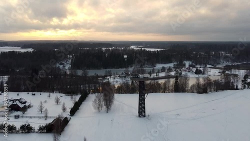 Aerial drone flying away from Rõuge Pesapuu observation tower in Southern Estonia in winter photo