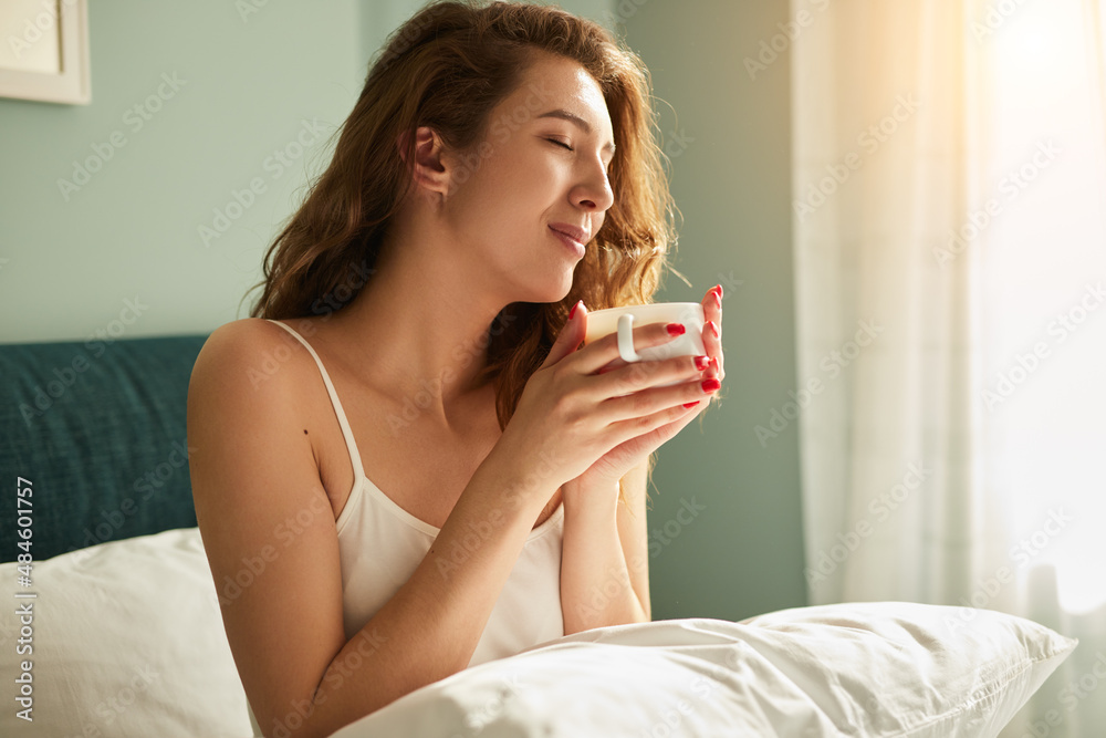 Woman with coffee on bed Woman with coffee on bed