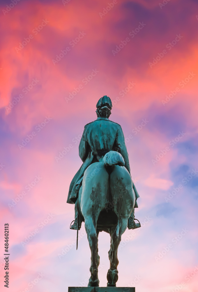 Equestrian statue of seen from behind riding into a colorful sunset sky. Equestrian statue of seen from behind riding into a colorful sunset sky.