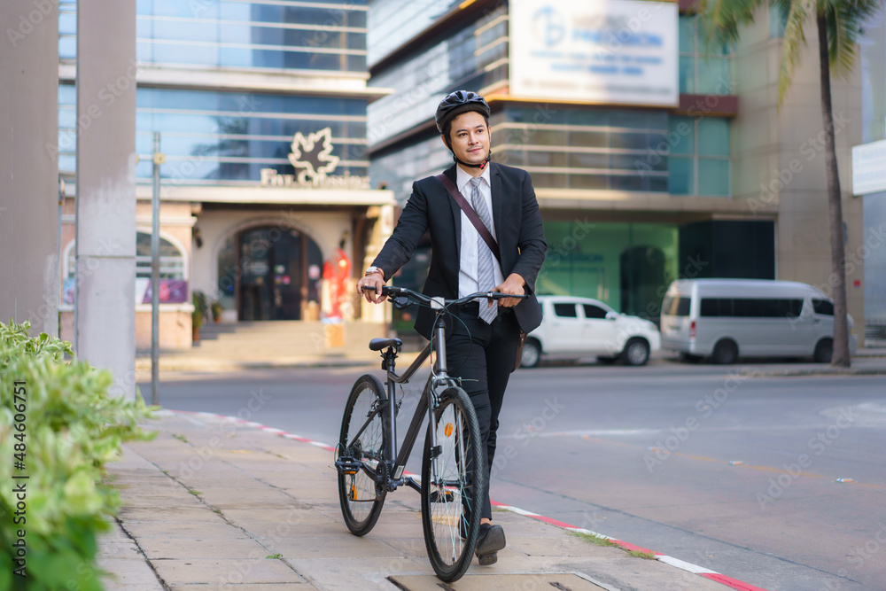 Asian businessman pushing his bicycle from home in the morning preparing to ride his bicycle to work. Eco tranportation..