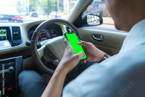 Driving car and using phone. Distracted driver texting with mobile cellphone. Irresponsible man checking message with smartphone in traffic. Auto accident concept. Holding smart device in hand.