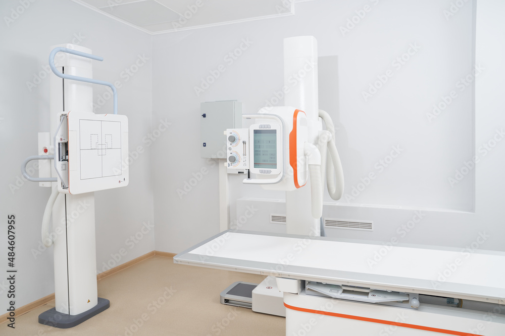 Modern cabinet of radiology and ultrasound tools in clinic with white walls and interior. Empty area for diagnostic after work day. Concept of professional tools treating and check of health. Modern cabinet of radiology and ultrasound tools in clinic with white walls and interior. Empty area for diagnostic after work day. Concept of professional tools treating and check of health.