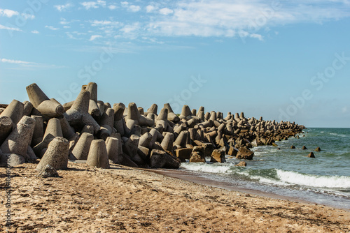 Northern Breakwater built as crucial part of Liepaja fortress and military port,Latvia.Favourite spot to watch sunset and fishing in Baltic Sea.Sandy beach on sunny summer day.Concrete protection photo