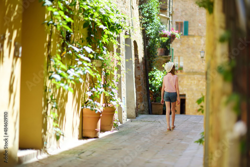 Young girl exploring in Pienza, a village located in the beautiful Tuscany valley, known as the 'ideal city of the Renaissance' and a 'capital' of pecorino cheese. © MNStudio