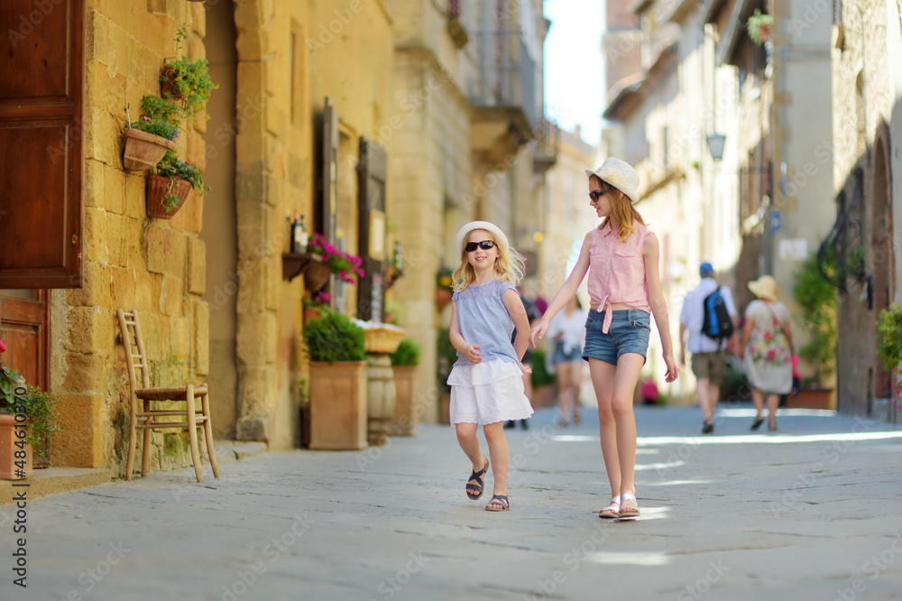 Young sisters exploring in Pienza, a village located in the beautiful Tuscany valley, known as the 'ideal city of the Renaissance' and a 'capital' of pecorino cheese.