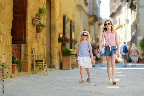 Young sisters exploring in Pienza, a village located in the beautiful Tuscany valley, known as the 'ideal city of the Renaissance' and a 'capital' of pecorino cheese. © MNStudio