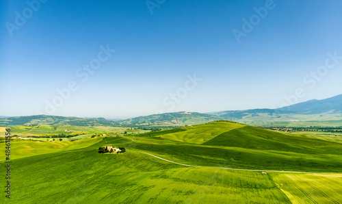 Wallpaper Mural Stunning aerial view of green fields and farmlands with small villages on the horizon. Rural landscape of rolling hills, curved roads and cypresses of Tuscany, Italy. Torontodigital.ca