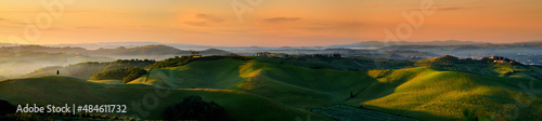 Stunning morning view of fields and farmlands with small villages on the horizon. Rural landscape of rolling hills, curved roads and cypresses of Tuscany, Italy.