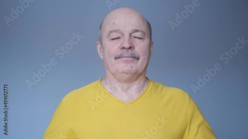 Senior hispanic man relaxing with closed eyes breathing deeply.