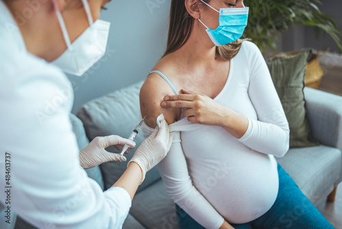 Female doctor giving the coronavirus vaccine to a young pregnant woman. Antibodies  immunize population. side effects  risk people  antibodies  new normal  covid-19.