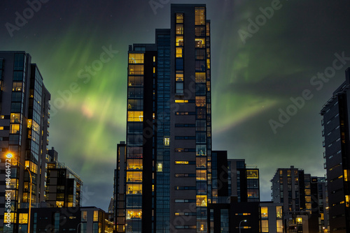 Aurora Borealis over the capital of Iceland. Modern high-rise buildings in central Reykjavik at night with the Northern Lights in the background.