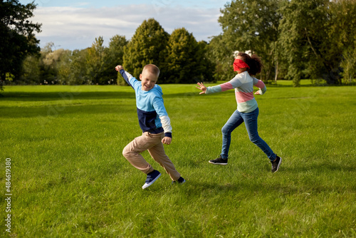 childhood, leisure and people concept - group of happy children playing tag game and running at park © Syda Productions