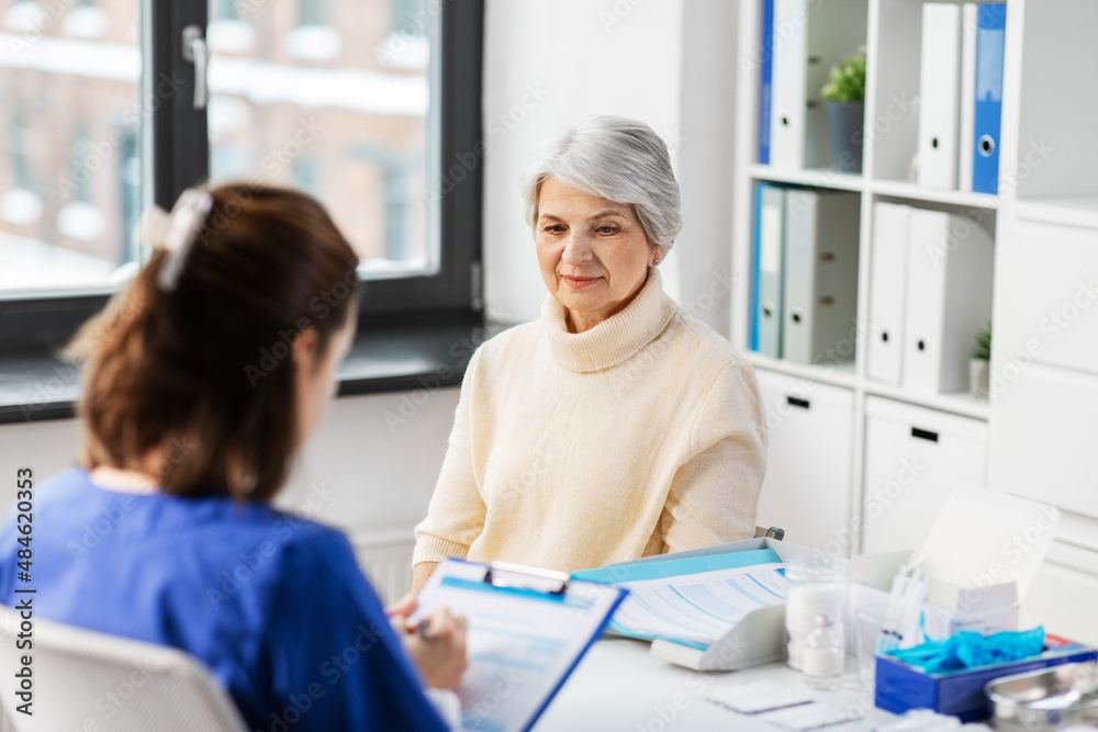 medicine, health and vaccination concept - doctor with clipboard and senior woman at hospital medicine, health and vaccination concept - doctor with clipboard and senior woman at hospital