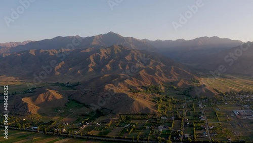 Collines et montagnes au bord du lac Issykul au Kirghizistan, soleil couchant. photo