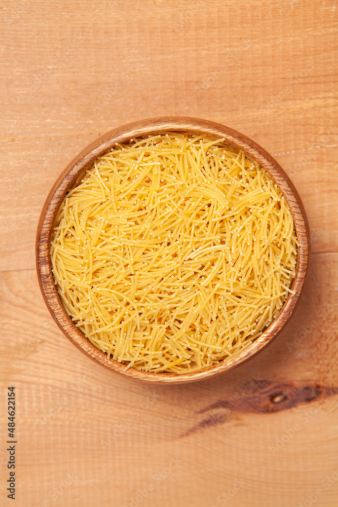 Vermicelli in the wooden plate on wooden background. Vermicelli in the wooden plate on wooden background.