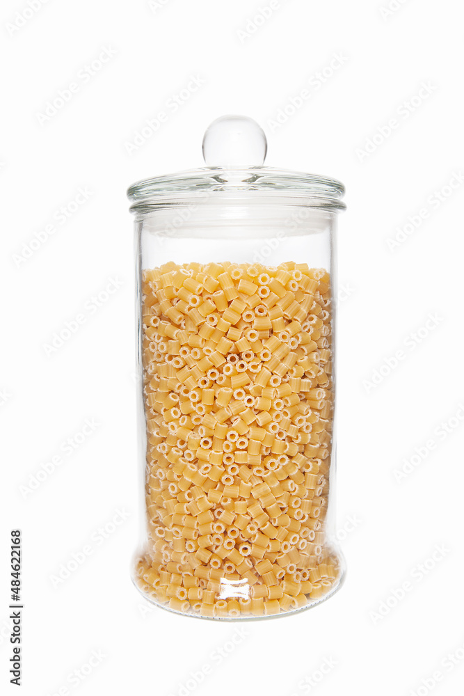 Uncooked pasta in glass jar on white background. Uncooked pasta in glass jar on white background.