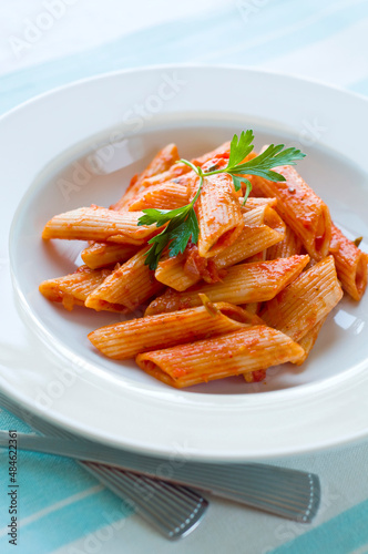 Close up of Penne pasta with tomato sauce. Scrumptious Italian cuisine.