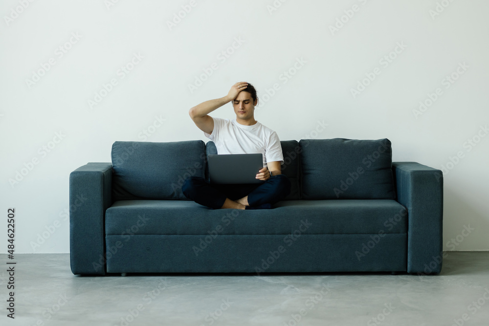 Upset desperate man having problems with wasting money, overspending,, scam and digital fraud. Frustrated disappointed shopaholic, bankrupt holding credit card at laptop, touching face Upset desperate man having problems with wasting money, overspending,, scam and digital fraud. Frustrated disappointed shopaholic, bankrupt holding credit card at laptop, touching face