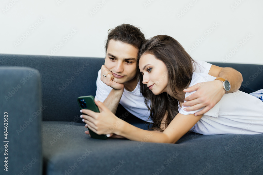 Boyfriend and girlfriend talking while looking at phone.