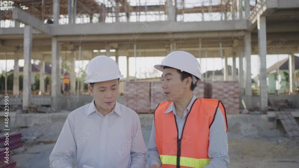 Construction engineering team. A male engineer and a male construction supervisor inspecting the construction house site.
