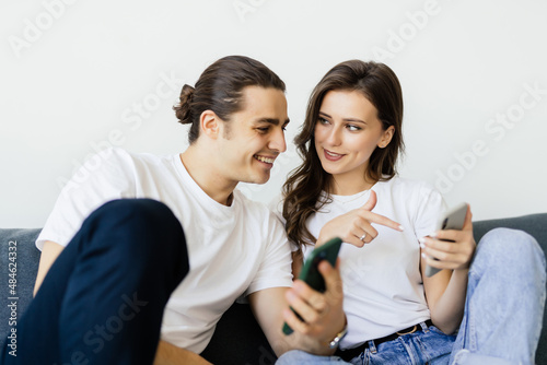 We can well afford to buy it. Happy loving married couple make payment purchase at ecommerce web site online using phone app credit card. Smiling young spouses engaged in shopping at internet pay safe