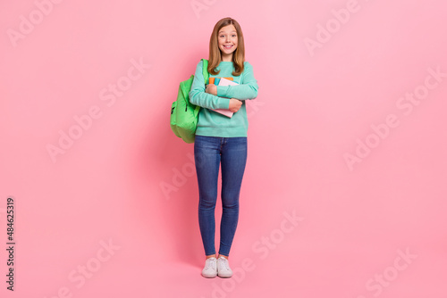 Photo of charming girl wear turquoise sweater hugging school supplies isolated pink color background