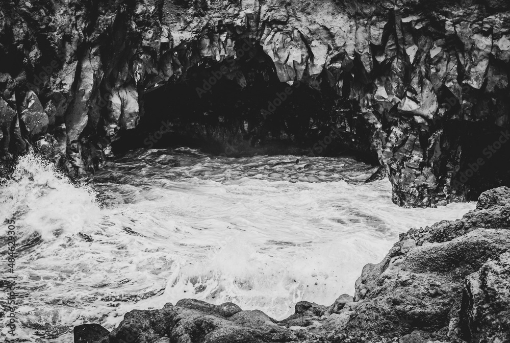 black and white cave and restless sea strikes the rocks.
beautifull and dramatic cave