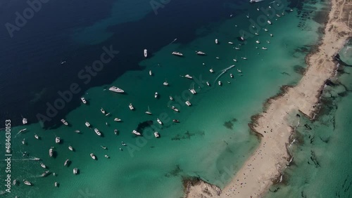 Aerial view of the white sandy beach of Formentera, moving in a forward direction at high speed. A perfect establishing shot of the entire beach. photo