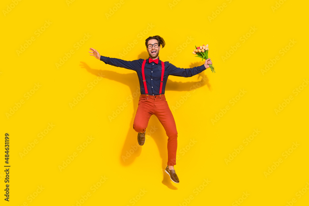Full length photo of young man energetic jumper hurry hold flowers husband romance isolated over yellow color background